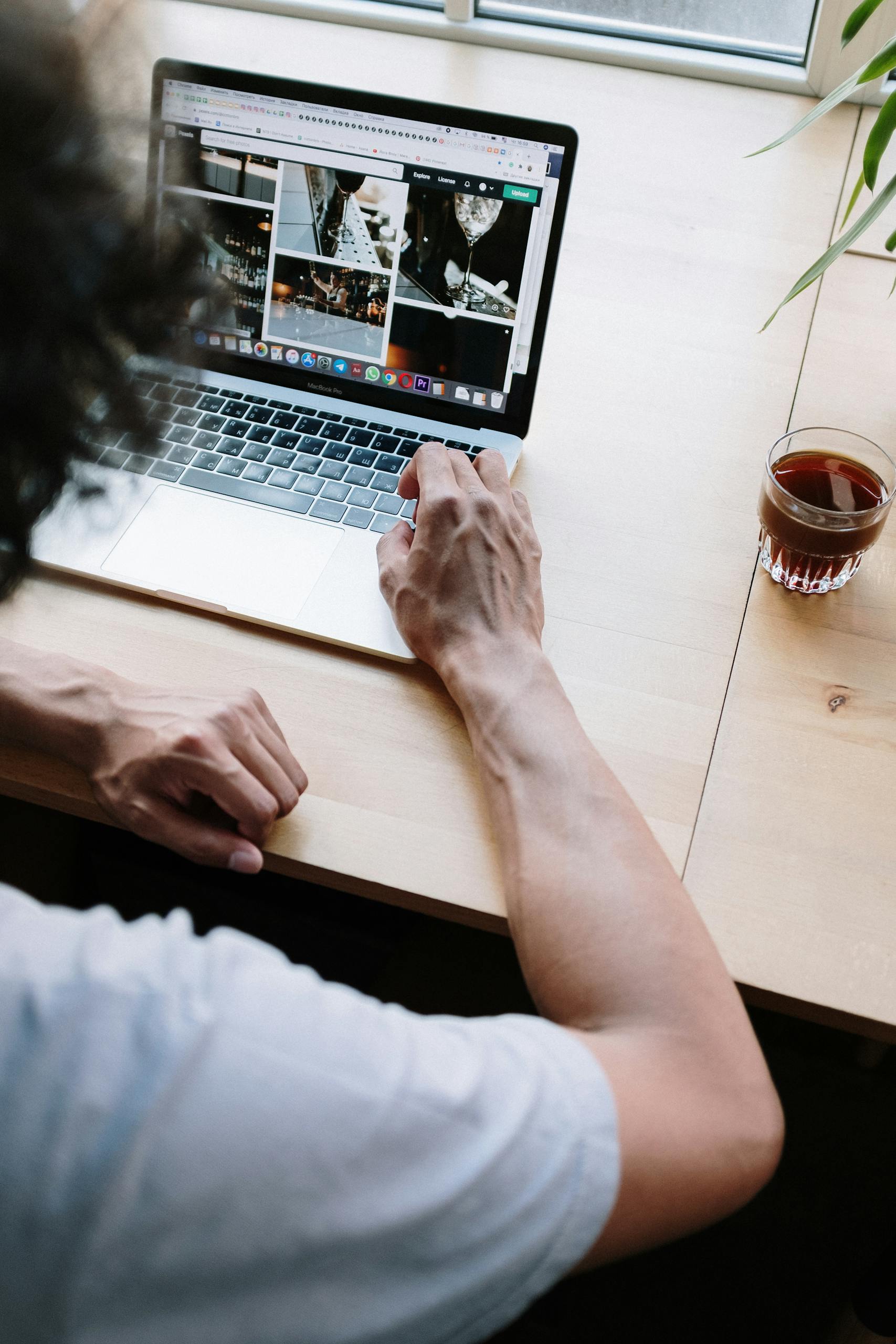 Man working on a laptop while enjoying coffee in a cozy setting.